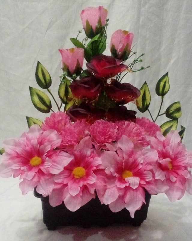 Floreira pequena com flores cor-de-rosa